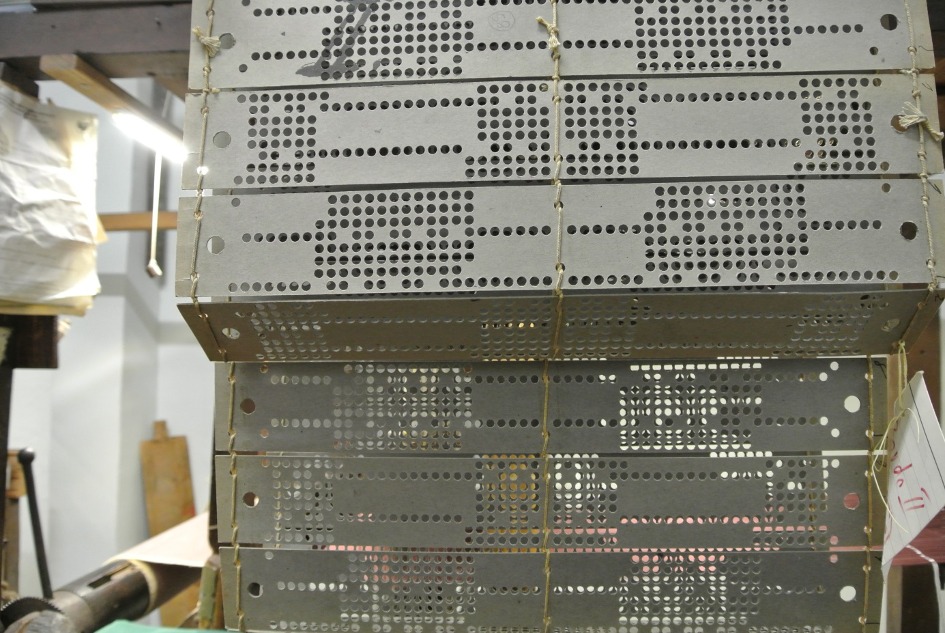 Laced punch-cards mounted on a Jacquard loom at HdS. Each line of dots on each card represents a “warp raised”.